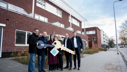 voor de nieuwbouw van links naar rechts wethouder Chris Hottentot, wethouder Mijnans, nieuwe bewoner, woonconsulent Marlies Bakelaar, bestuurder Maasdelta Groep Ruud van Nieuwaal en projectleider ABB Tim Schregardus